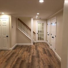 an empty room with hard wood floors and white doors