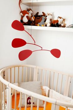 a baby crib with stuffed animals on the shelves