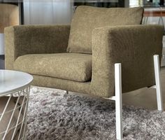 a chair sitting on top of a shaggy rug next to a white table and chairs