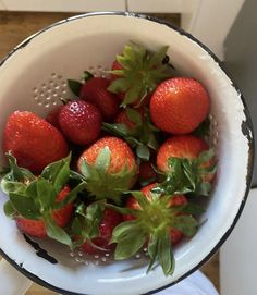 fresh strawberries in a colander ready to be washed