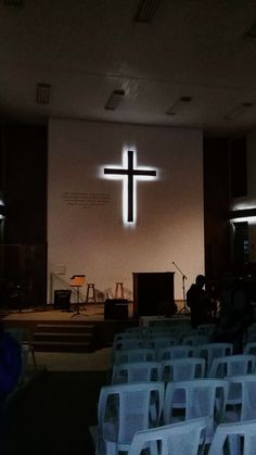 an empty church with chairs and a cross on the wall