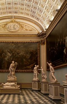 statues are lined up in the middle of a room with paintings on the walls and ceiling