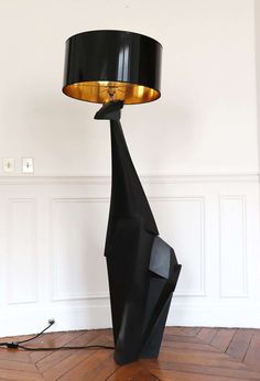 a lamp that is sitting on top of a wooden floor next to a white wall