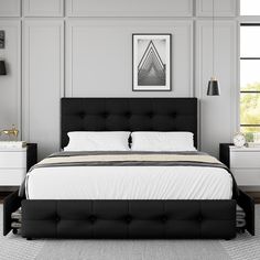 a black and white bed in a room with two nightstands on either side of the bed