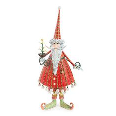 a red and white gnome figurine holding a christmas tree