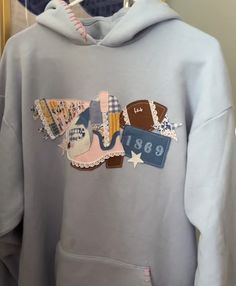 a gray sweatshirt with patches and numbers on it