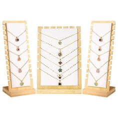 three pieces of jewelry are on display in front of a wooden frame with bead necklaces