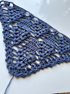 a blue crocheted doily sitting on top of a white countertop next to a pair of scissors