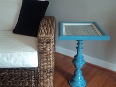 a blue table sitting on top of a wooden floor next to a white couch and chair