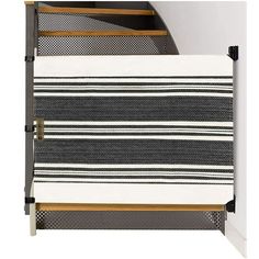 a black and white striped rug next to a stair case