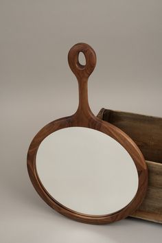 a wooden mirror sitting on top of a table