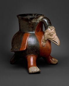 an old ceramic vase with a bird on it's body and head in the shape of a turtle