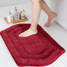 a person is standing on a red rug in the bathroom