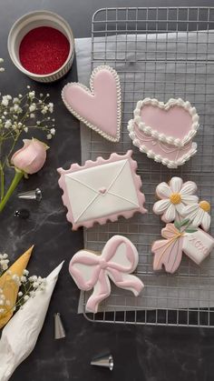 decorated cookies and flowers on a cooling rack