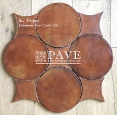 four round leather coasters sitting on top of a wooden floor