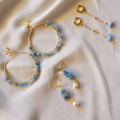 three pairs of blue beaded hoop earrings and two gold - plated ear rings