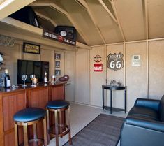 a living room filled with furniture next to a wall mounted sign and bar area in front of a tv