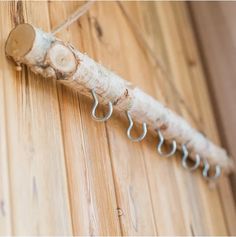 a close up of a piece of wood on a wall with hooks attached to it