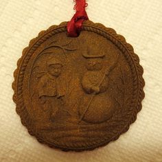 an ornament hanging on a white towel with a red ribbon around the edge