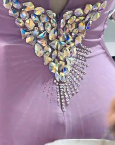 a woman in a purple dress is wearing a large crystal brooch on her waist