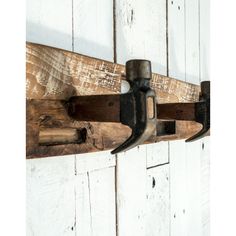 a coat rack made out of wooden planks with metal hooks hanging on the wall