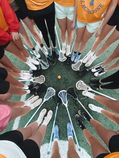 a group of people standing in a circle with their hands together and holding tennis rackets