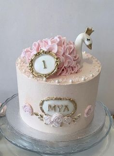 a cake decorated with pink flowers and a unicorn on top