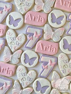 some cookies are decorated with pink, purple and white icing that spell out the name ava