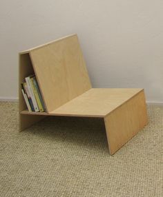 a small wooden book shelf sitting on the floor in front of a white wall and carpet