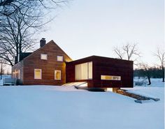 the house is surrounded by snow and has two large windows on each side of it