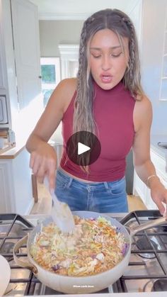 a woman in a red shirt is cooking food on the stove