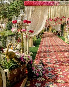 an outdoor wedding ceremony with floral decorations and flowers on the aisle leading to the altar