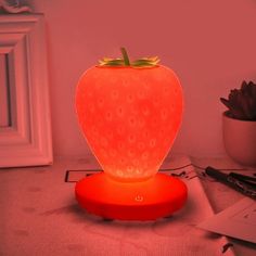 a strawberry shaped lamp sitting on top of a table