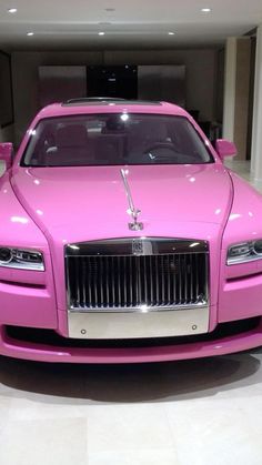 a pink car is parked in a showroom