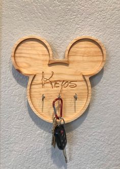 mickey mouse key holder with keys hanging from it's side and the word key to its ear