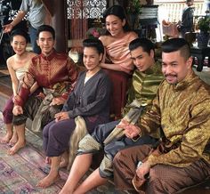 a group of people sitting next to each other on top of a carpeted floor