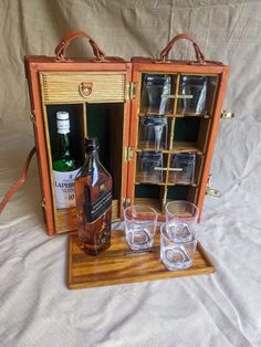 an old fashioned wooden case with glasses and bottles