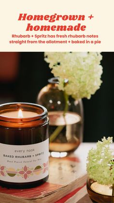 a candle sitting on top of a book next to a vase with flowers in it