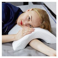 a woman laying on top of a bed with a pillow in front of her face