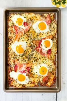 eggs and bacon on top of rice in a pan