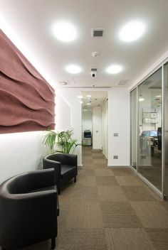 two black chairs sitting in an office lobby