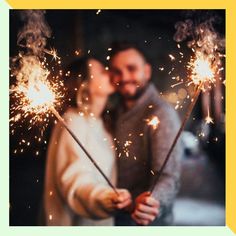 a man and woman holding sparklers in their hands