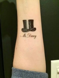 a man's arm with a hat and name tattoo on the left side of his arm