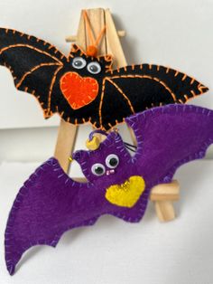 two bat puppets are hanging on a wooden easel