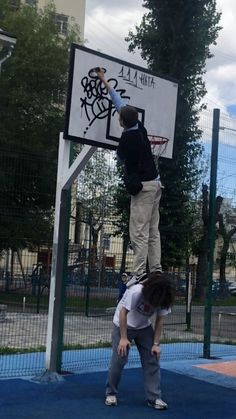 two boys playing basketball on a playground