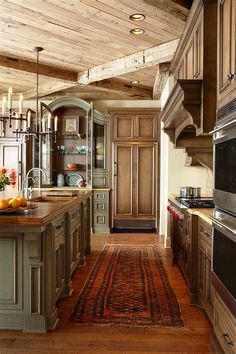 a large kitchen with wooden floors and an area rug on the floor that matches the cabinets