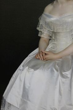 a woman in a white dress sitting down