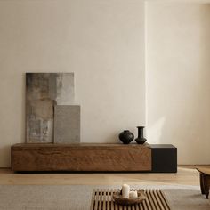 two black vases sitting on top of a wooden shelf in a living room next to a painting