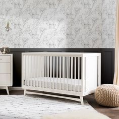 a white crib sitting in a room next to a dresser