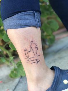 a woman's foot with a tattoo on her left leg that has a drawing of a man holding a dog